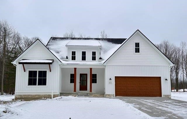 modern inspired farmhouse featuring a garage and covered porch