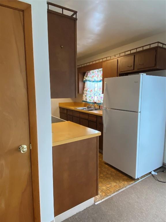 kitchen with sink, stovetop, and white refrigerator