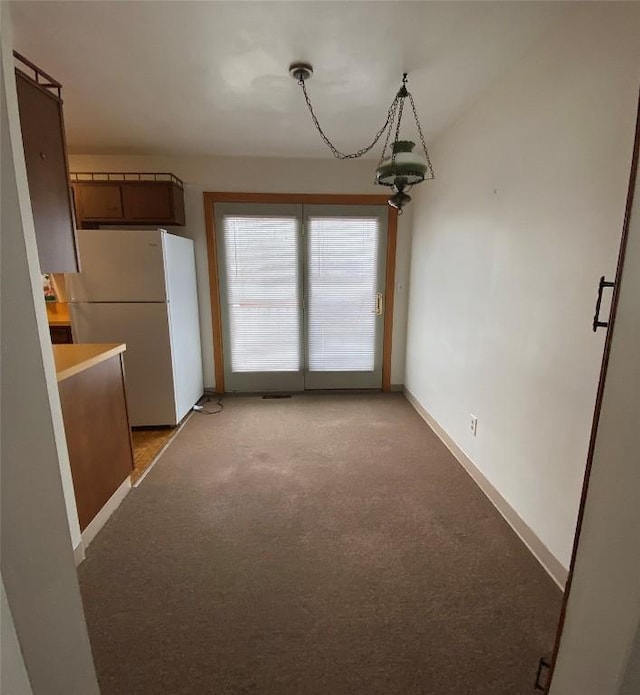 unfurnished dining area featuring light carpet