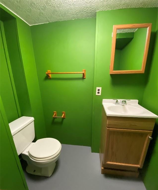 bathroom featuring vanity, a textured ceiling, and toilet