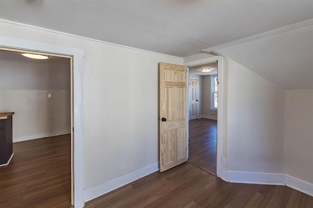 interior space with lofted ceiling, dark wood-type flooring, and baseboards