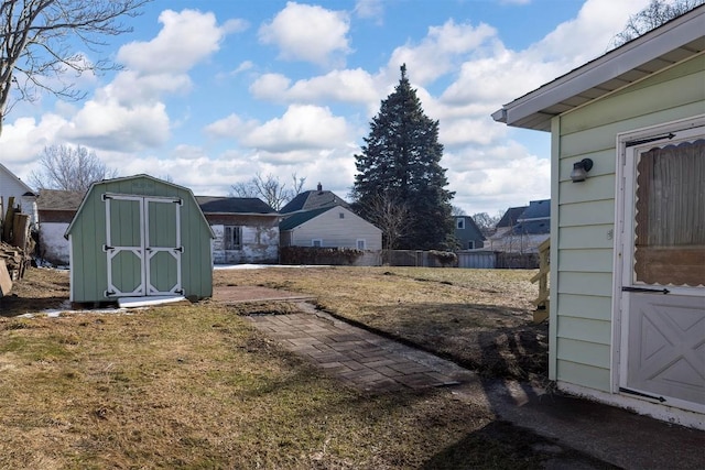 view of yard with an outbuilding, fence, and a storage shed