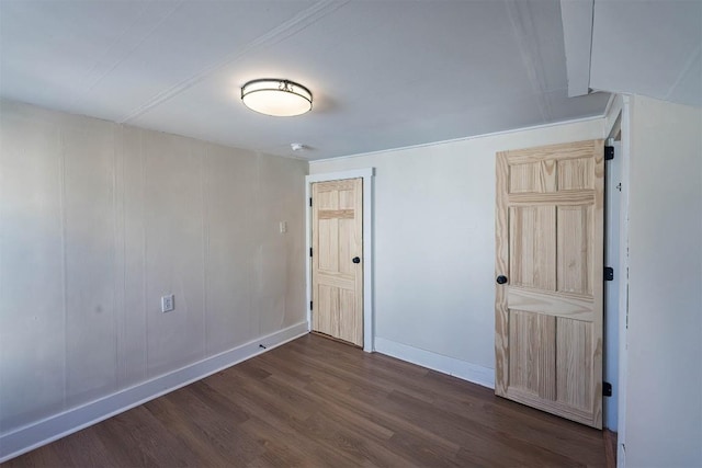 empty room with dark wood-style flooring and baseboards