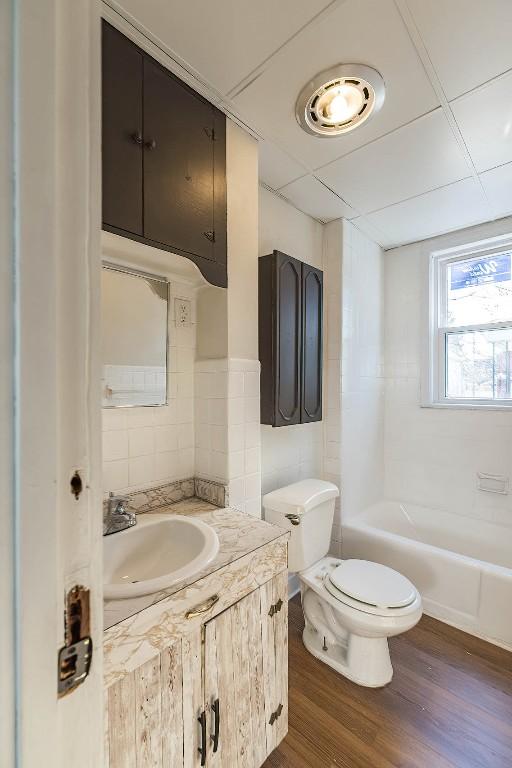 full bathroom featuring tasteful backsplash, visible vents, toilet, wood finished floors, and vanity