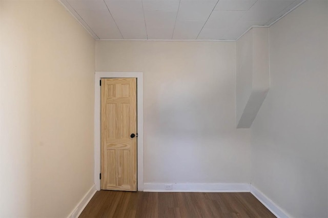 empty room featuring dark wood finished floors and baseboards