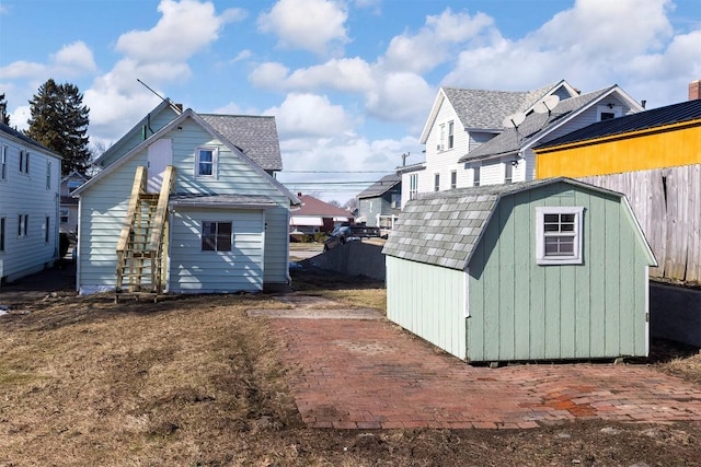 view of shed with stairs and fence