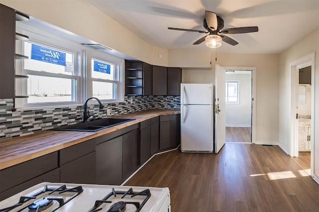 kitchen featuring white appliances, a sink, wood counters, decorative backsplash, and open shelves