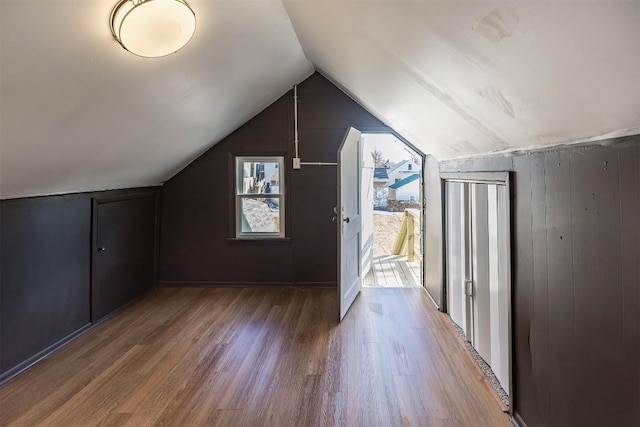 additional living space with vaulted ceiling and wood finished floors