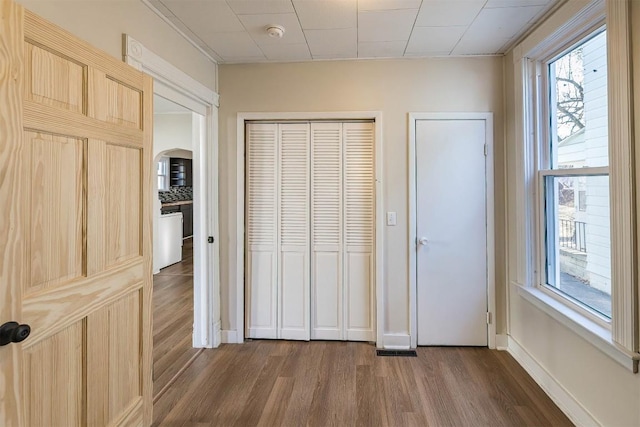 unfurnished bedroom featuring a closet, dark wood finished floors, and baseboards