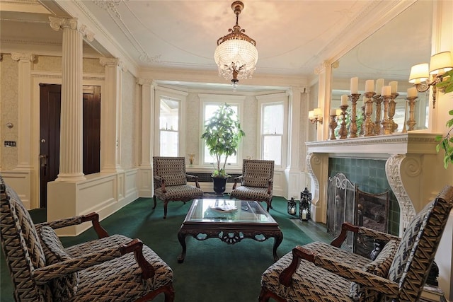 living area with a tile fireplace, carpet flooring, decorative columns, and ornamental molding