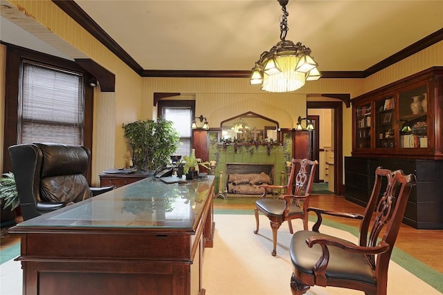 home office with a notable chandelier, a fireplace, light wood-type flooring, and crown molding