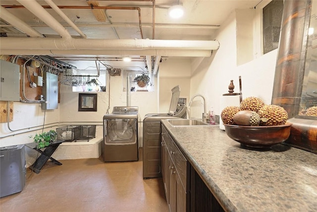 laundry room with washer and clothes dryer, cabinets, sink, and electric panel