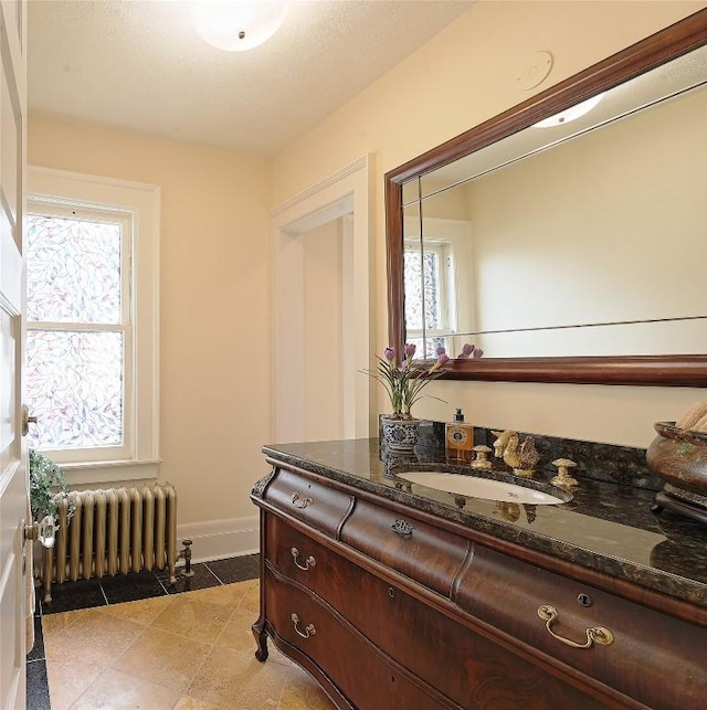 bathroom featuring tile patterned floors, vanity, radiator heating unit, and a wealth of natural light