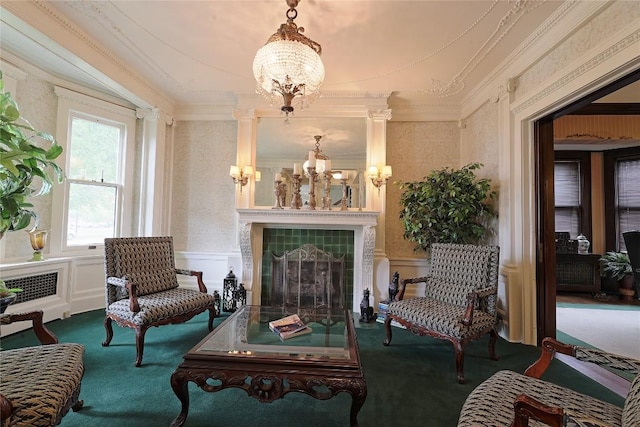 sitting room featuring ornamental molding, carpet floors, a fireplace, and an inviting chandelier