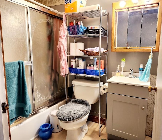 full bathroom with vanity, combined bath / shower with glass door, and toilet