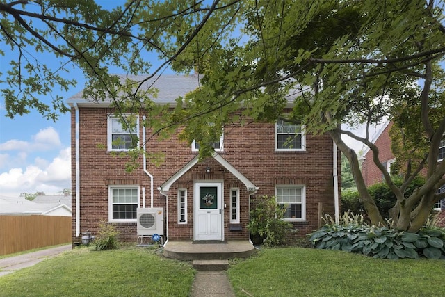 view of front facade with ac unit and a front lawn