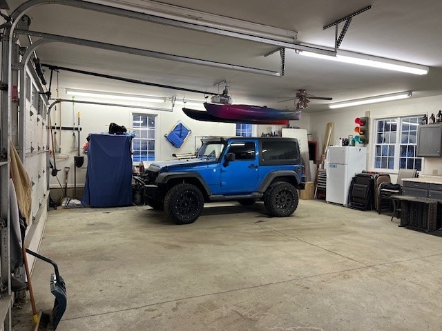 garage featuring a garage door opener and freestanding refrigerator