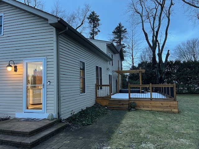 view of property exterior with a wooden deck and a lawn