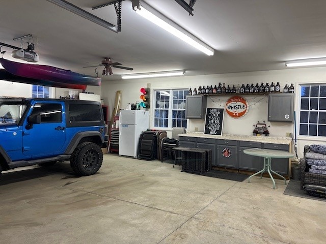 garage with a garage door opener and freestanding refrigerator