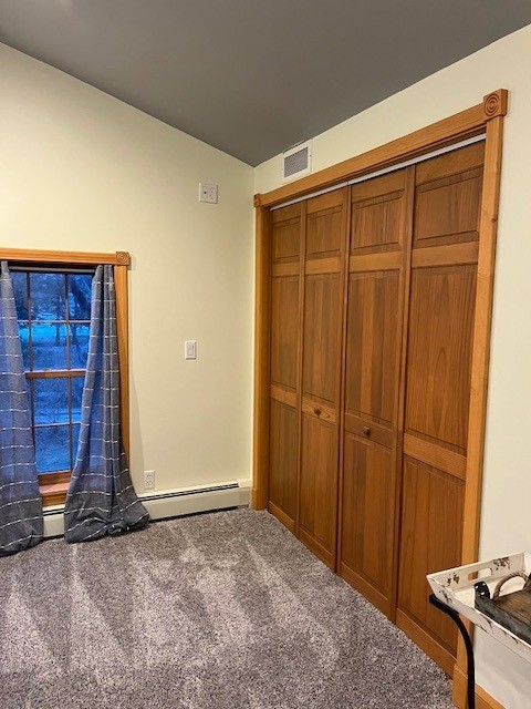 unfurnished bedroom with a closet, visible vents, and carpet floors