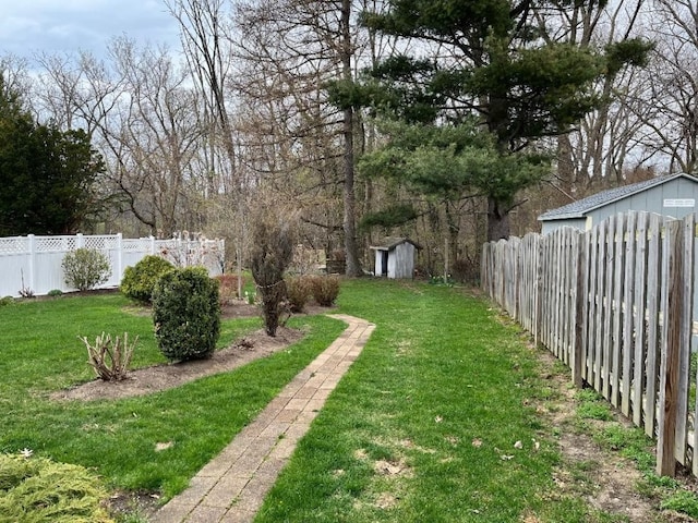 view of yard with a fenced backyard, an outdoor structure, and a storage shed