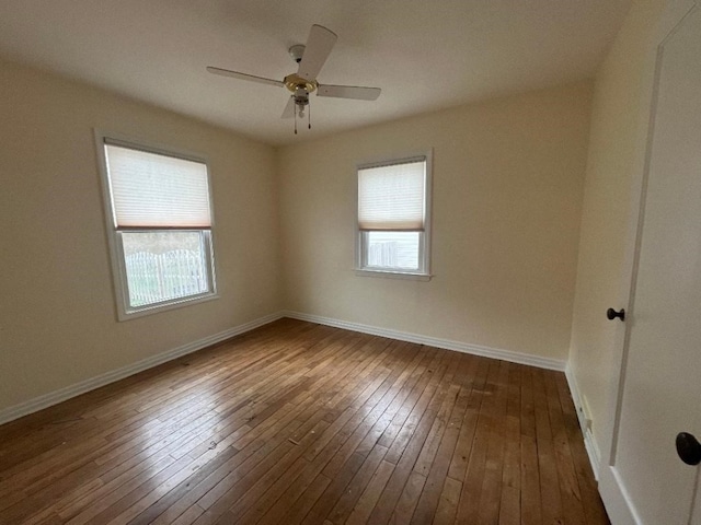 spare room featuring ceiling fan, baseboards, and dark wood-style flooring