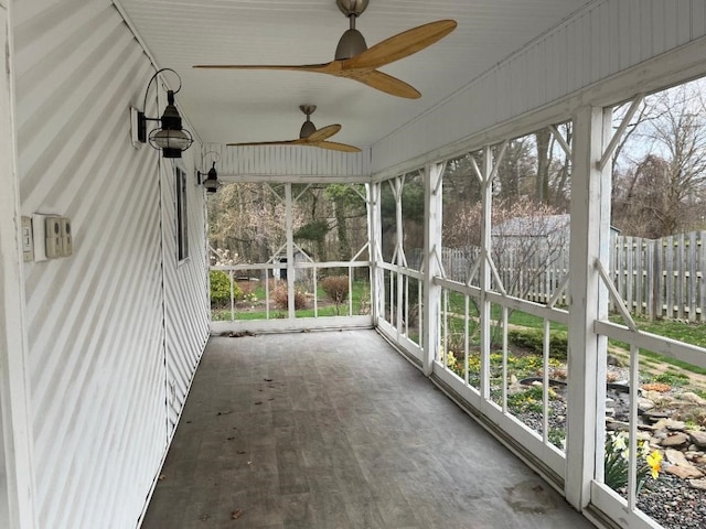 unfurnished sunroom featuring a ceiling fan