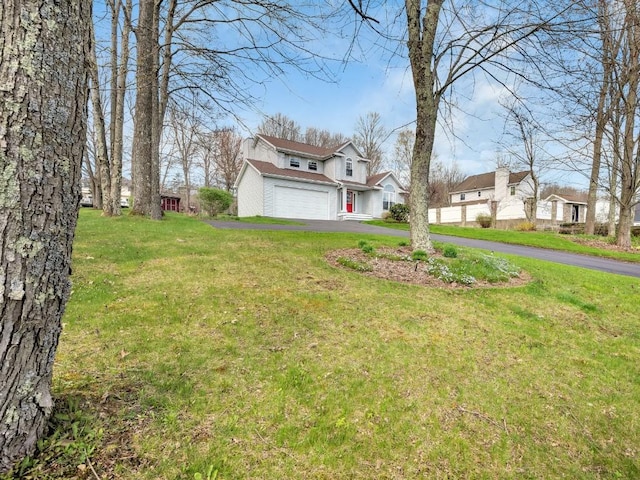 view of yard featuring driveway and a garage