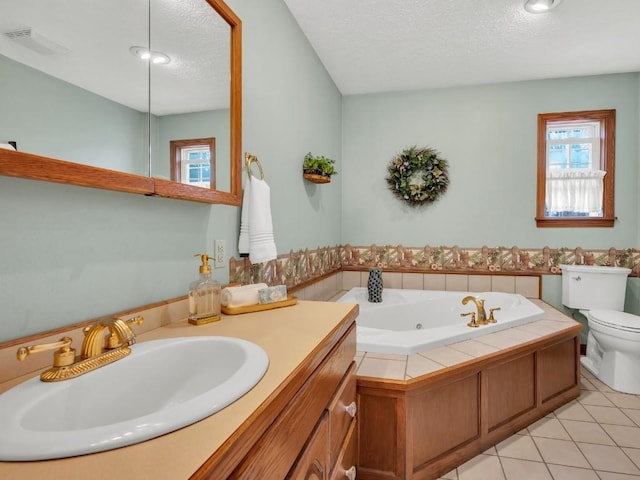 bathroom featuring visible vents, toilet, a tub with jets, a textured ceiling, and tile patterned floors