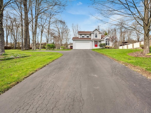 traditional home with fence, a garage, driveway, and a front lawn