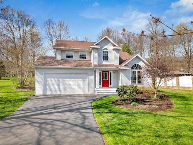traditional-style house featuring a front lawn and aphalt driveway