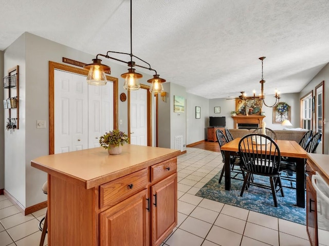 dining room with baseboards, a textured ceiling, light tile patterned flooring, and a notable chandelier