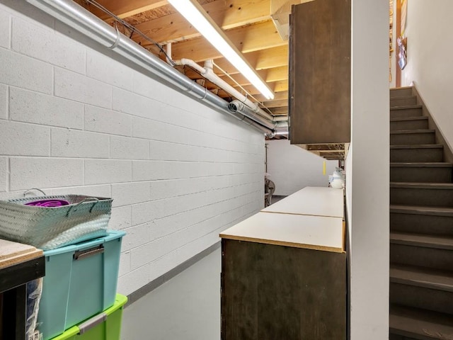 finished below grade area featuring stairs and concrete block wall