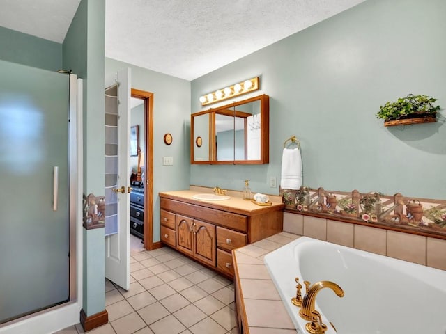 full bath featuring a garden tub, a textured ceiling, tile patterned flooring, a shower stall, and vanity