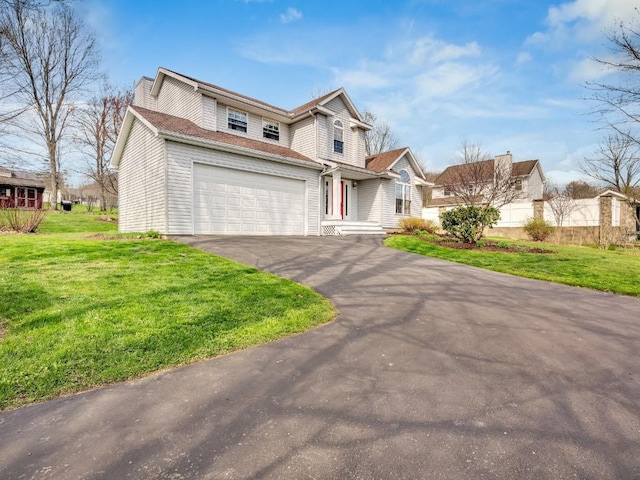 traditional-style house with an attached garage, aphalt driveway, and a front yard