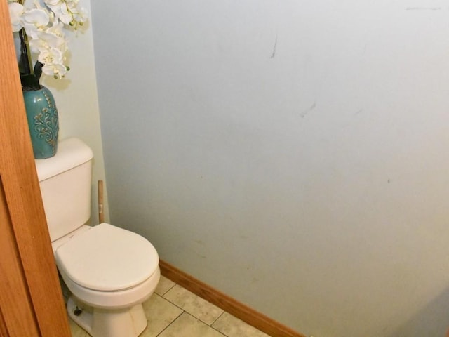 bathroom featuring toilet, baseboards, and tile patterned floors