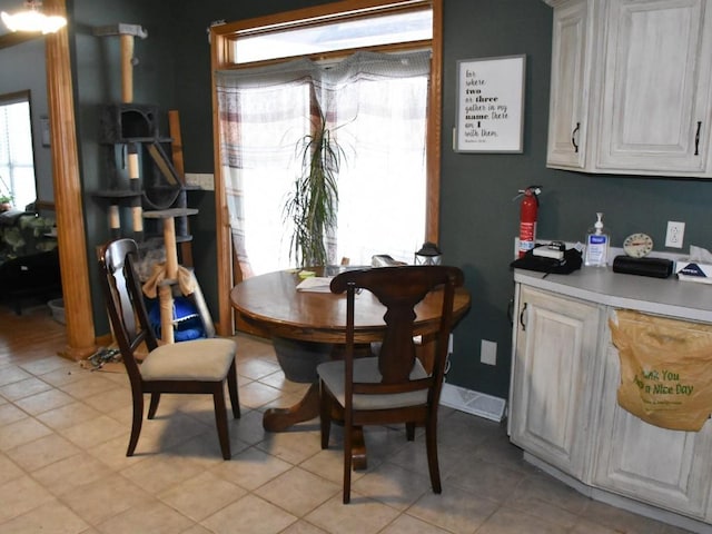 dining space featuring plenty of natural light, baseboards, and light tile patterned floors