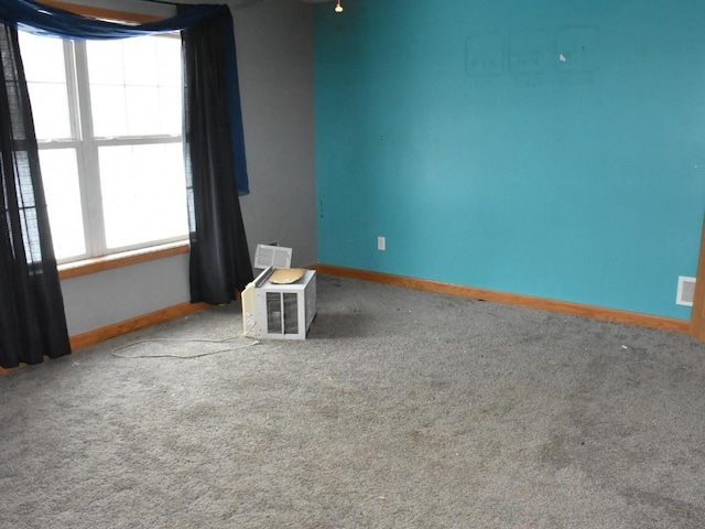 unfurnished room featuring carpet and baseboards