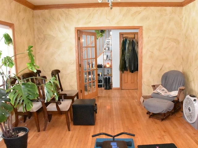 sitting room with french doors, wood finished floors, and crown molding