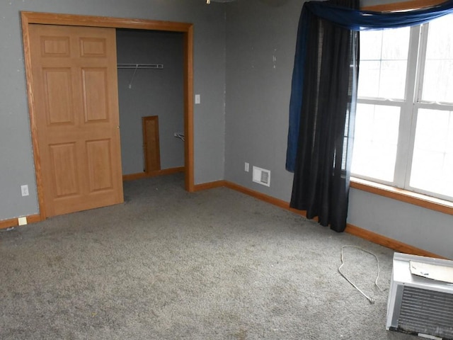 unfurnished bedroom featuring carpet, a closet, visible vents, and baseboards