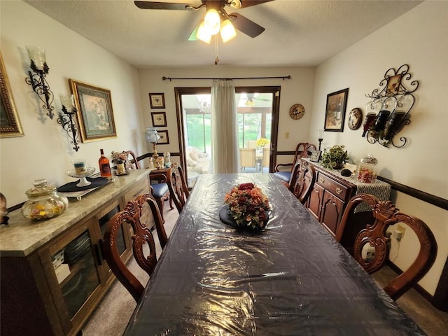 dining area with a textured ceiling, ceiling fan, and light carpet