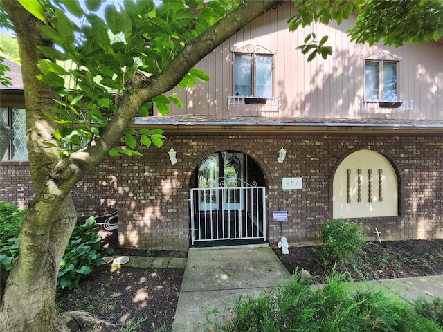 property entrance with brick siding and a gate