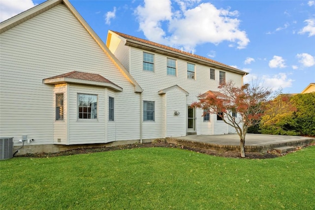 back of property with a lawn, cooling unit, and a patio area