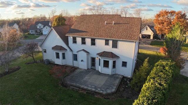 exterior space featuring a front yard, a patio, and central air condition unit