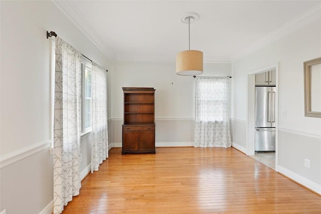 spare room featuring ornamental molding and light wood-type flooring