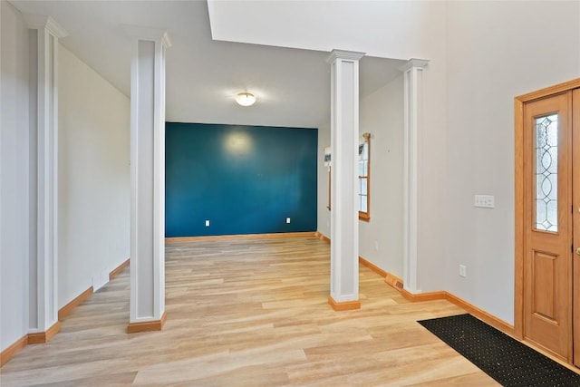 entrance foyer with light wood-type flooring and decorative columns