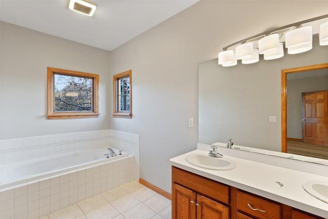 bathroom featuring tile patterned floors, tiled bath, and vanity