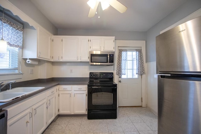 kitchen with white cabinetry, sink, stainless steel appliances, and ceiling fan