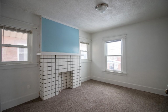 carpeted empty room featuring a fireplace and a textured ceiling