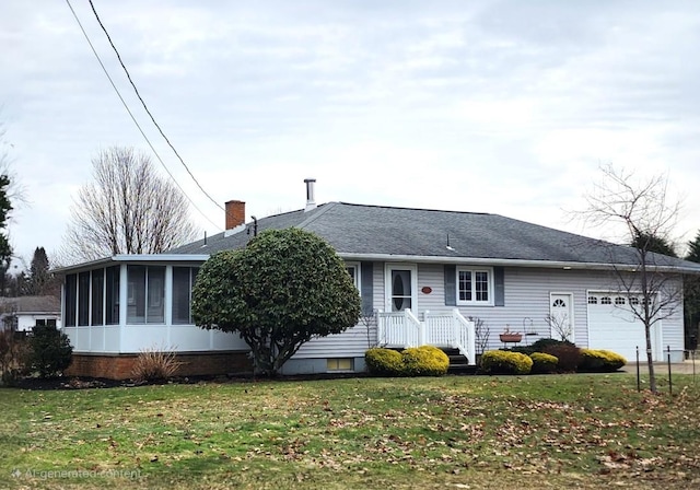 single story home with an attached garage, a sunroom, a chimney, and a front lawn